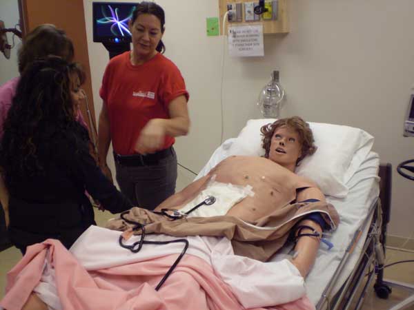 Nursing instructors demonstrate one of the robots used to train student nurses. The robots are designed to be as life-like as possible, with a simulated breath, pulse and bowel sounds.