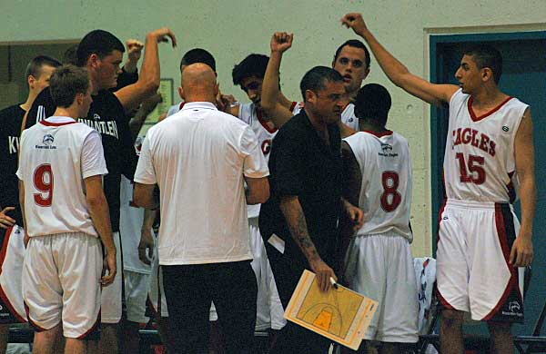 The Kwantlen Eagles convene and listen to head coach Bernie Love during a time-out.