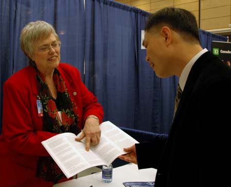 Sue Sparlin gives Daniel Lin information on the Boucher Institute for Natropathic Medacine.