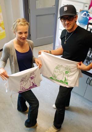 Heather Hastings and Andrew Passas display t-shirts sold Tuesday in Richmond. (Jacob Zinn photo)