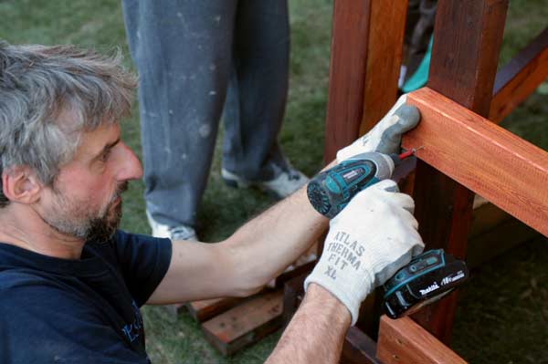 Keefer secures the ladder that will lead up to a new wooden playhouse for the children. The house was donated to the family by Home Depot. (Mitch Thompson photo)